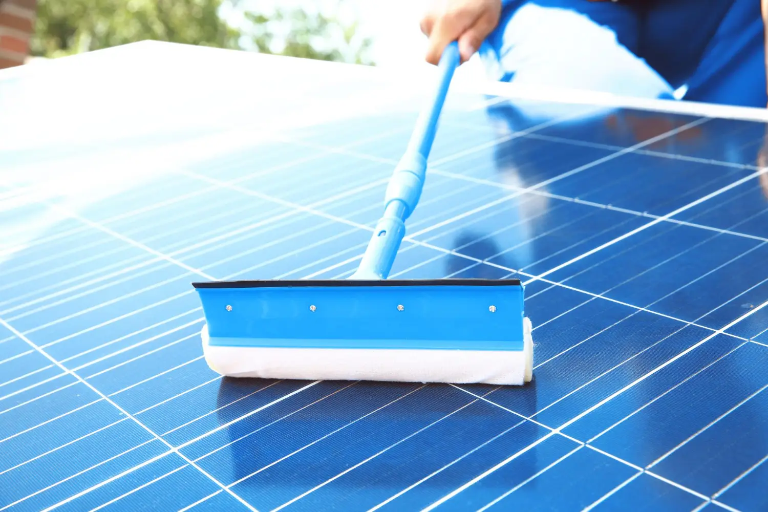 Cleaning a solar panel with a brush.